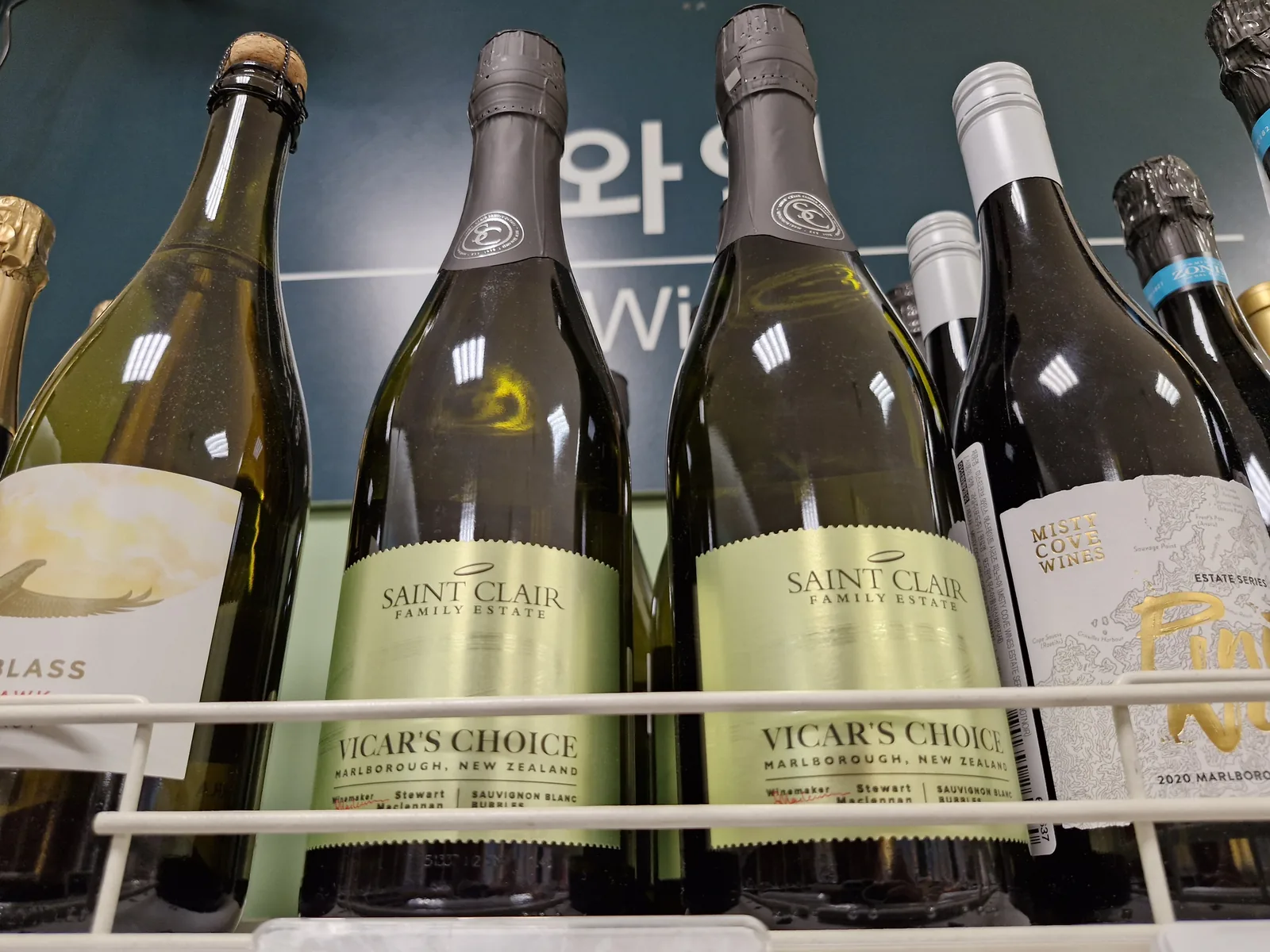 생 클레어 비카스 초이스 소비뇽 블랑 버블 두 병 정면, 회색 캡슐 마감과 연두색 라벨, 오른쪽에 미스티 코브 피노누아